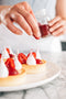 chef sprinkling raspberry powder over lemon tart with lemon curd filling fresh raspberries and raspberry marshmallow made fresh by tartlet bakery