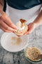 garnishing carrot cake tart with white chocolate pearls made fresh by tartlet bakery