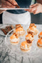 shaving cinnamon on top of carrot cake tart made from vanilla shortcrust pastry, carrot cream filling, carrot jelly, mascarpone cream, carrot cake, walnuts, white chocolate pearls, grated carrot and cinnamon made fresh by tartlet bakery