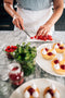 chef slicing fresh raspberries to garnish lemon tart with lemon curd filling made fresh by tartlet bakery
