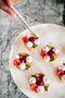 Adding fresh lemon thyme petals over Lemon tart with sweet shortcrust pastry, lemon curd, raspberry jelly, raspberry marshmallows, fresh raspberries made fresh by tartlet bakery